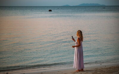 Mujer al teléfono en una playa